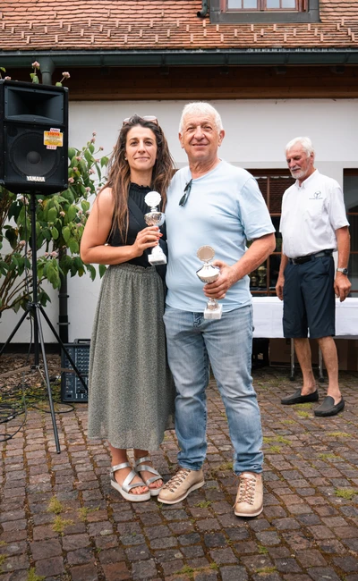Zwei Personen halten Pokale auf der Lindau-Klassik Rallye.