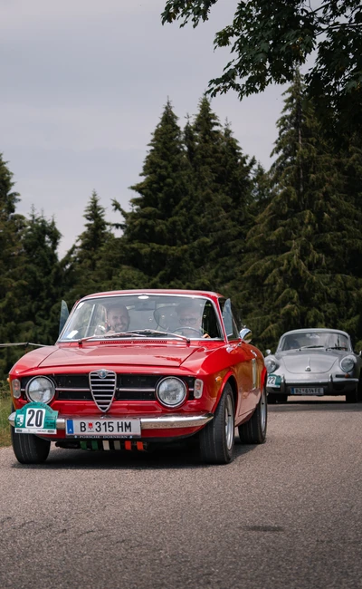 Roter Alfa Romeo f&auml;hrt auf einer Landstra&szlig;e w&auml;hrend der Lindau-Klassik Rallye.