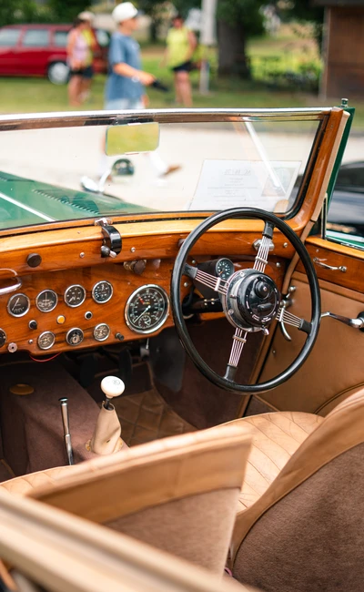 Innenansicht eines klassischen Autos mit Holzverkleidung und Rundinstrumenten auf der Lindau-Klassik Rallye