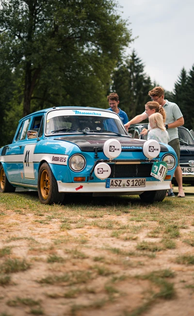 Ein blaues Rennfahrzeug mit Startnummer 41 auf der Lindau-Klassik Rallye, umgeben von Menschen.