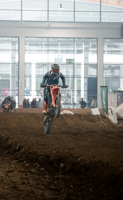 Motocrossfahrer springt mit KTM-Motorrad &uuml;ber H&uuml;gel auf der Motorradwelt 2026