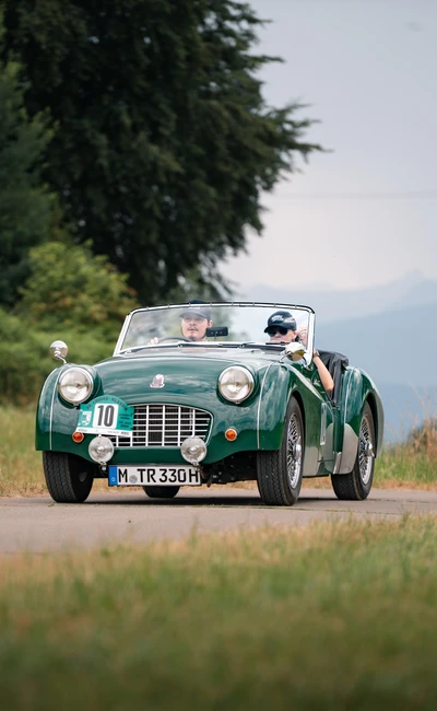 Gr&uuml;ner klassischer Sportwagen f&auml;hrt auf einer Stra&szlig;e w&auml;hrend der Lindau-Klassik Rallye.