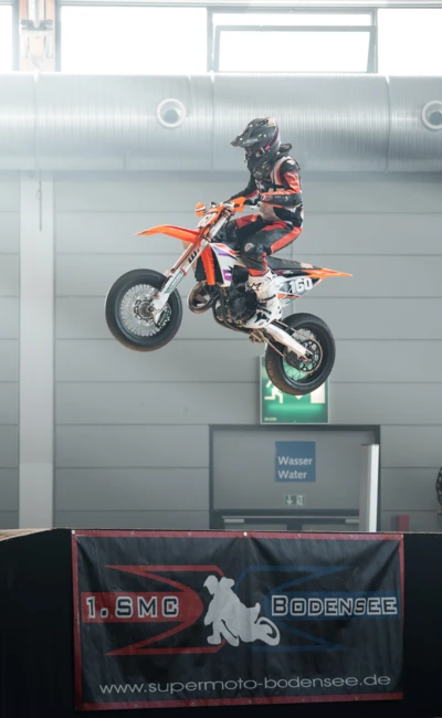 Motorradfahrer springt mit KTM in der Luft auf der Motorradwelt 2026 Messe