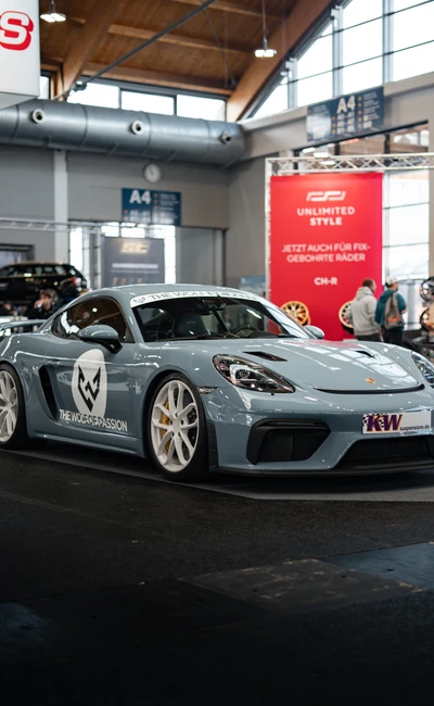 Grauer Porsche 718 Cayman mit Sponsorenlogo auf der Tuning World Bodensee 2026