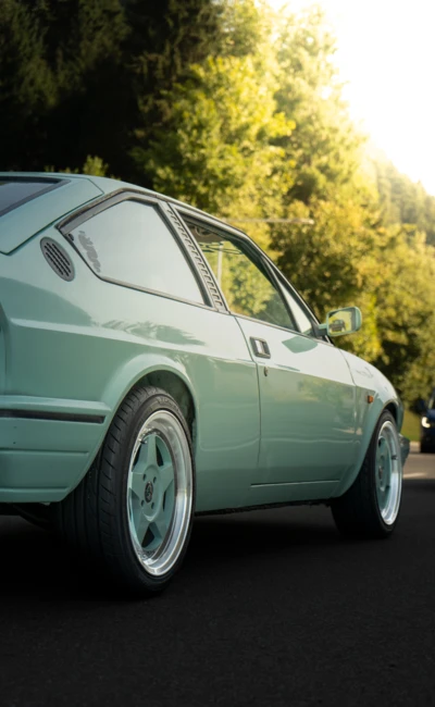 Mintgr&uuml;nes Auto auf einer Stra&szlig;e mit B&auml;umen im Hintergrund, Oldtimertreffen Langen 2025