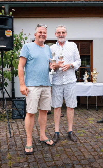 Zwei M&auml;nner halten Pokale w&auml;hrend der Lindau-Klassik Rallye