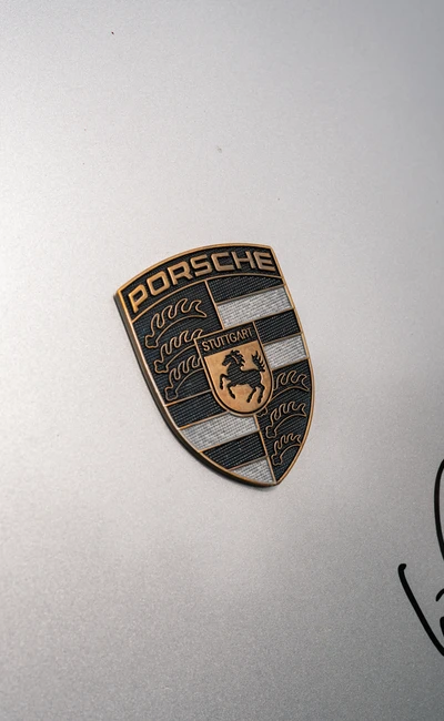 Porsche-Schild mit Logo auf silbernem Fahrzeuglack