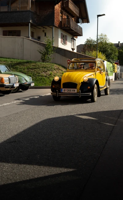 Gelbes Oldtimerauto f&auml;hrt auf einer Stra&szlig;e beim Oldtimertreffen Langen 2025
