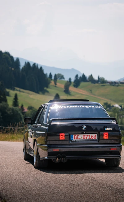 BMW M3 auf der Lindau-Klassik Rallye, idyllische Landschaft im Hintergrund