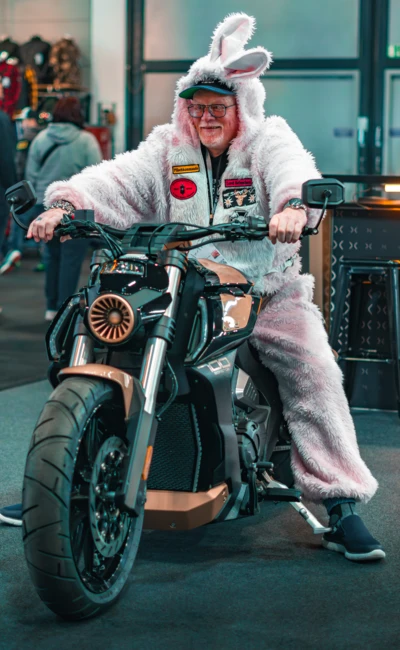 Mann in einem Hasenanzug sitzt auf einem Motorrad auf der Motorradwelt 2026