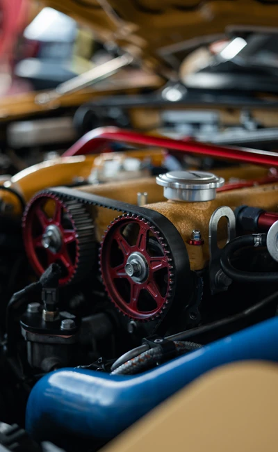 Detailansicht eines Motorraums mit roten Zahnr&auml;dern und blauen Schl&auml;uchen