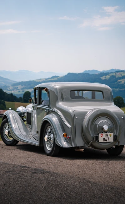 Silbernes Oldtimer-Auto auf einer Landstra&szlig;e bei der Lindau-Klassik Rallye