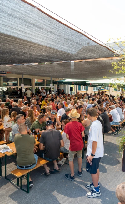 Menschenmenge in einem schattigen Au&szlig;enbereich beim Oldtimertreffen Langen 2025