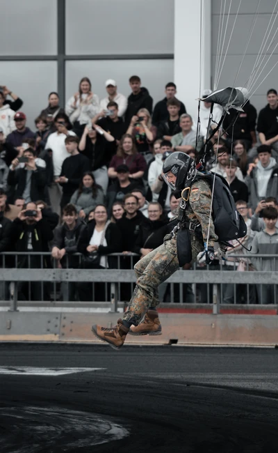 Soldat mit Fallschirm schwebt &uuml;ber Zuschauer auf Tuning World Bodensee 2026