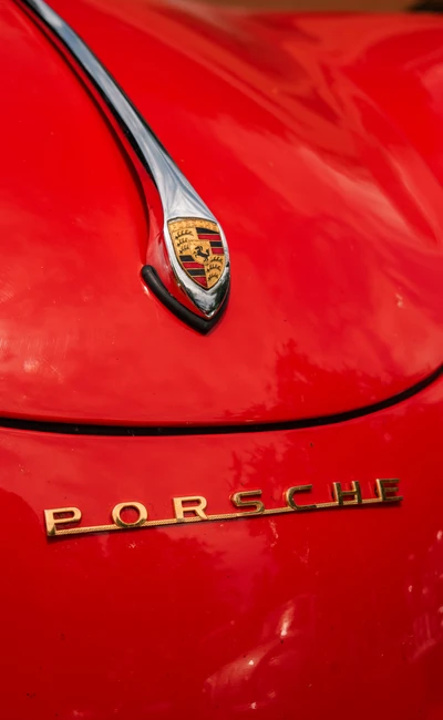 Roter Porsche mit gl&auml;nzendem Emblem auf der Lindau-Klassik Rallye