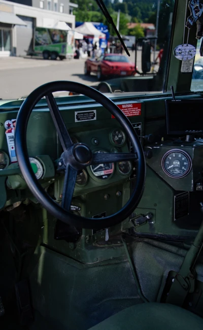 Innenansicht eines milit&auml;rischen Fahrzeugs mit gr&uuml;nem Armaturenbrett und Lenkrad