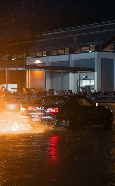 Schwarzes Driftfahrzeug mit Rauch und Wassernebel auf der Tuning World 2026.