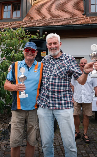 Zwei M&auml;nner halten Pokale auf der Lindau-Klassik Rallye