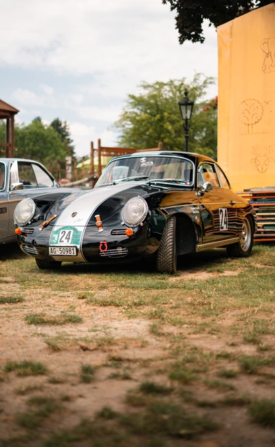 Schwarzer Porsche 356 auf der Lindau-Klassik Rallye, umgeben von klassischen Autos