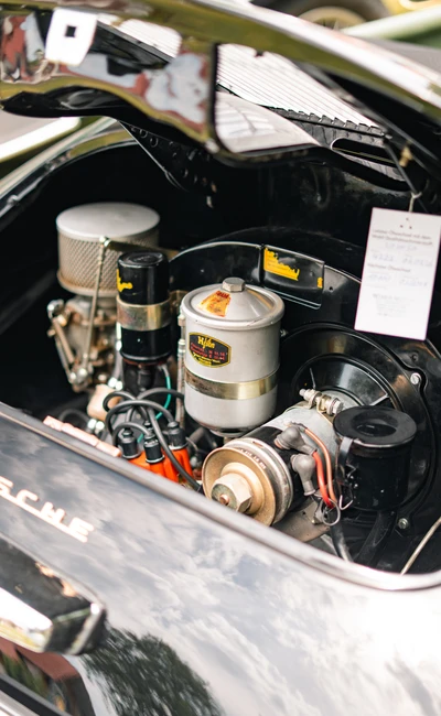 Motorraum eines Porsche mit sichtbarem Motor und Details