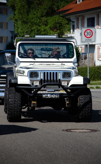 Wei&szlig;er Jeep mit gro&szlig;em Offroad-Fahrwerk auf der Stra&szlig;e in Lindenberg