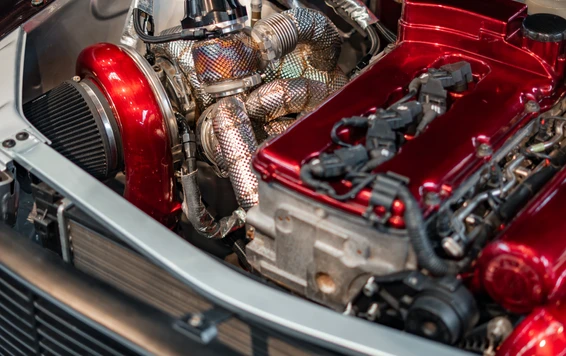 Tuning World Bodensee 2026 in Friedrichshafen Motorraum eines Modifikationsfahrzeugs mit rotem Motorblock und Turbo