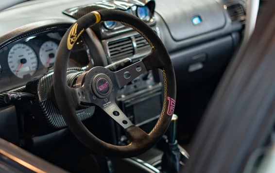 Innensicht eines modifizierten Fahrzeugs auf der Tuning World Bodensee. Motorraum mit Rennlenkrad und Armaturen auf der Tuning World Bodensee 2026.