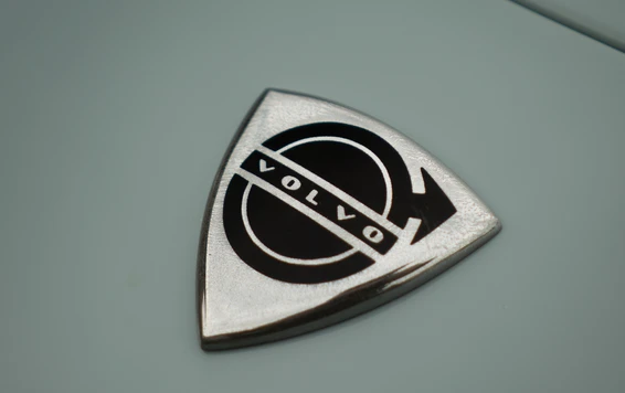 Logo eines Volvo-Fahrzeugs auf einem blauen Fahrzeuglack mit Chromdetails