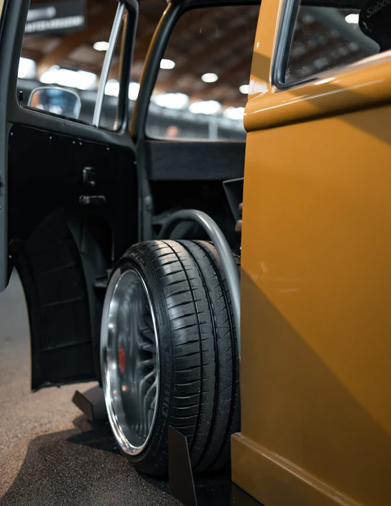 Gelbes Auto mit offenem T&uuml;r und gro&szlig;em Reifen bei der Tuning World Bodensee 2026.