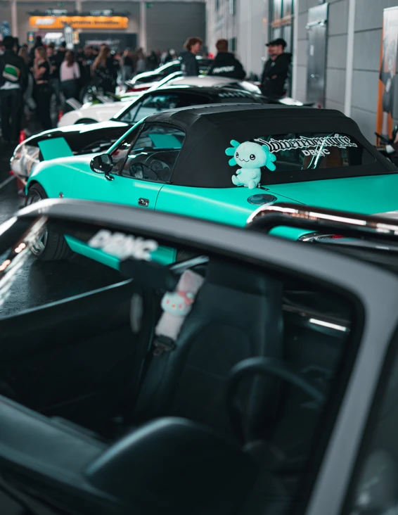 Vier modifizierte Autos in einem Innenraum mit Zuschauern auf der Tuning World Bodensee 2026