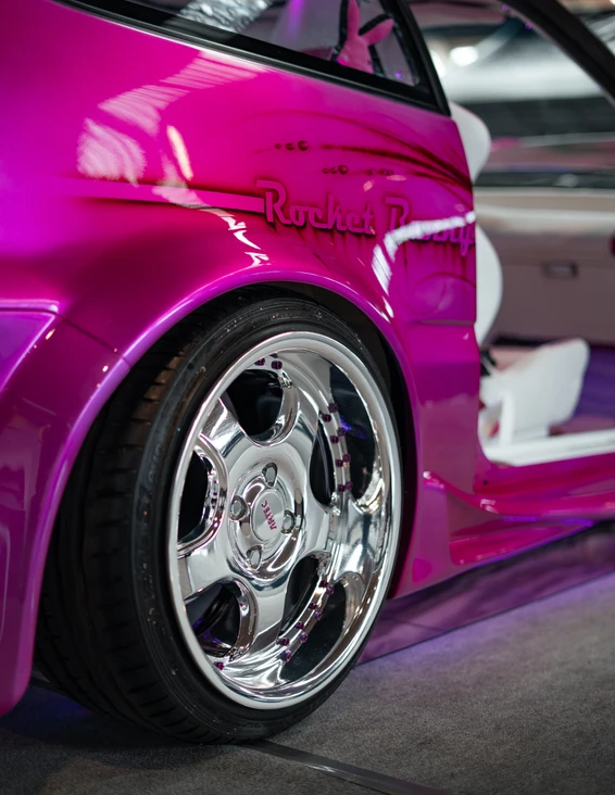 Detailaufnahme eines pink lackierten Autos mit verchromten Felgen auf der Tuning World Bodensee 2026